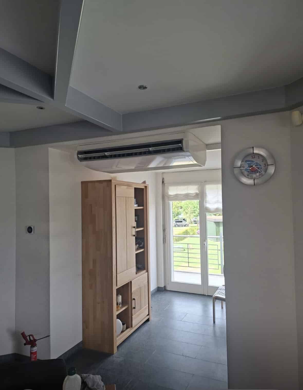 Unité de climatisation plafonnière blanche installée dans le séjour d'une villa