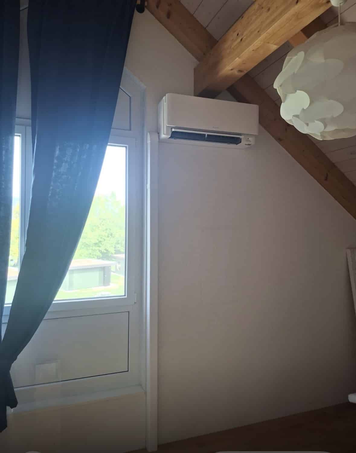 Unité murale Daikin Stylish installée dans une chambre sous combles avec poutres apparentes