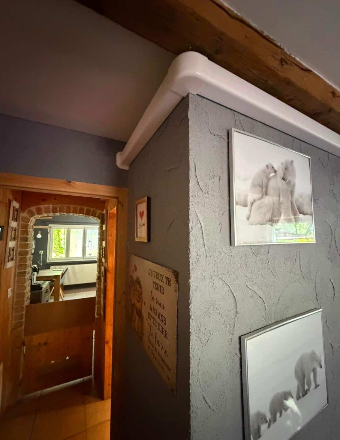 Goulotte blanche cheminant le long du plafond et de l'angle du mur intérieur
