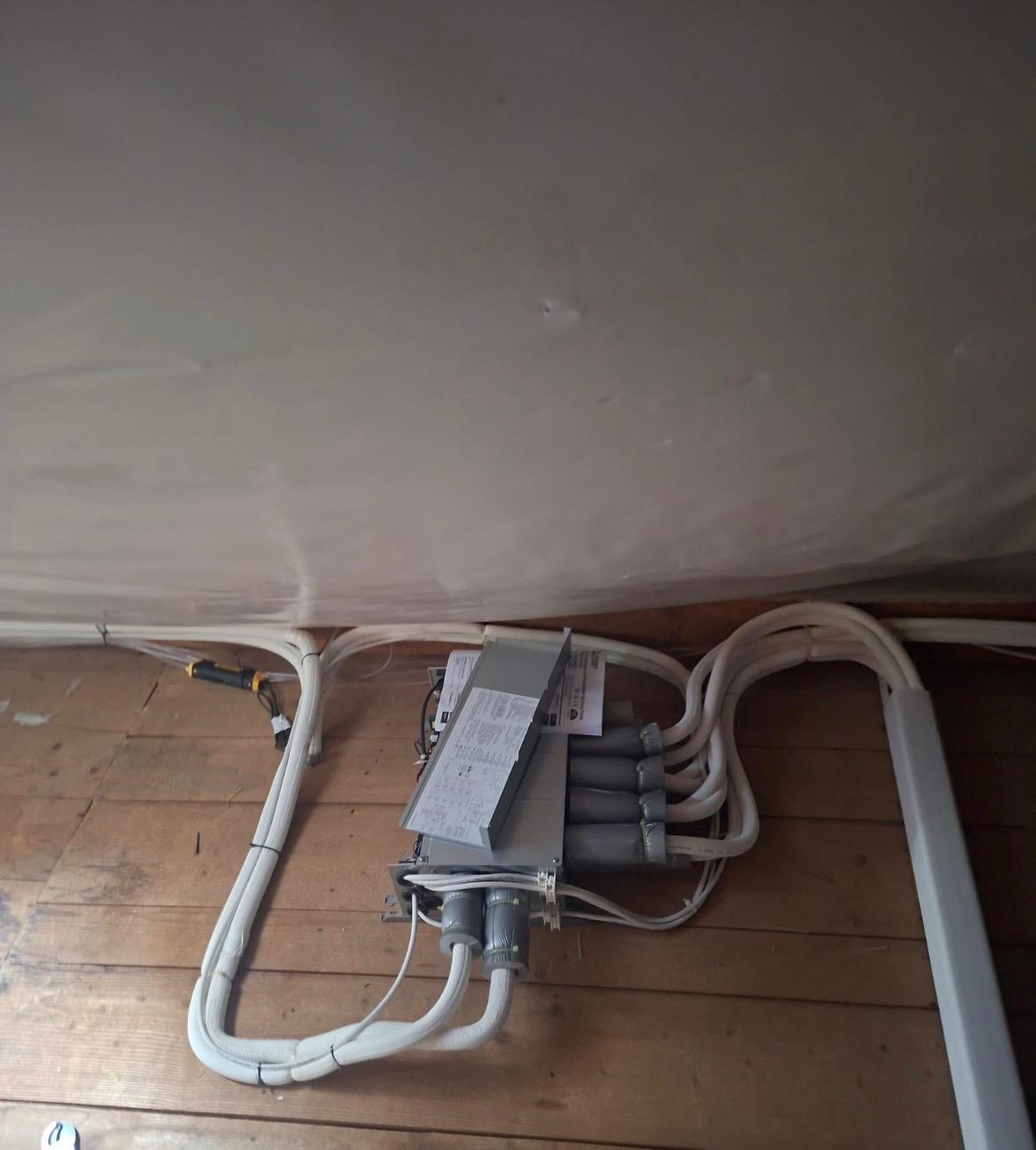 Boîtier de répartition frigorifique et liaisons isolées installés sous les combles d'une villa