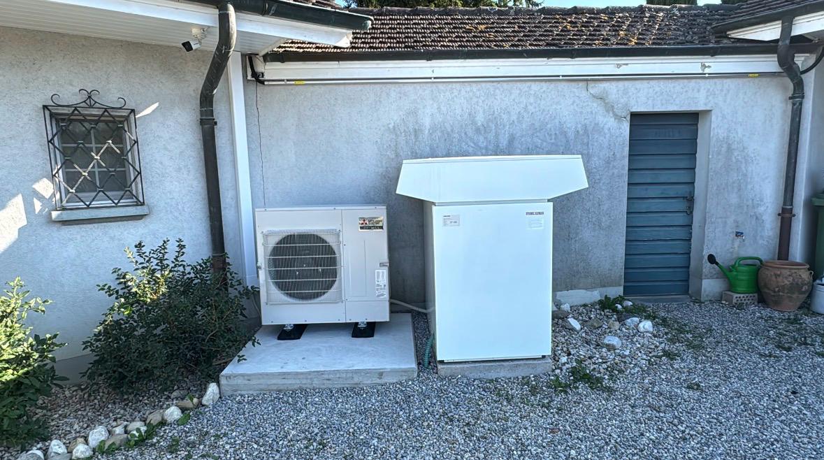Groupe extérieur Mitsubishi Electric posé sur un socle béton le long de la façade de la villa