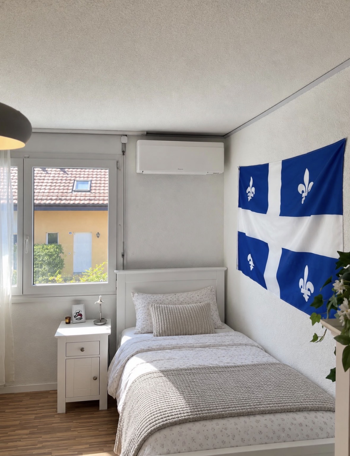 Unité murale de climatisation Daikin installée au-dessus d'un lit dans une chambre claire