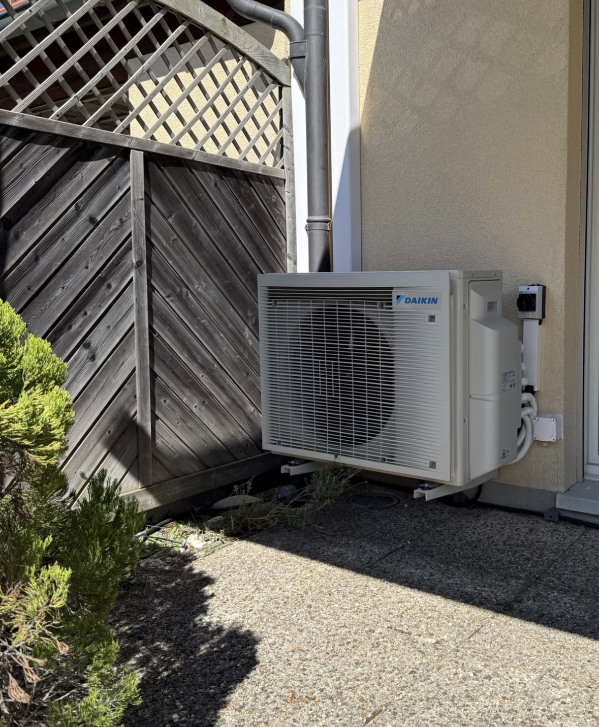 Unité extérieure Daikin posée sur plots le long de la façade de la villa
