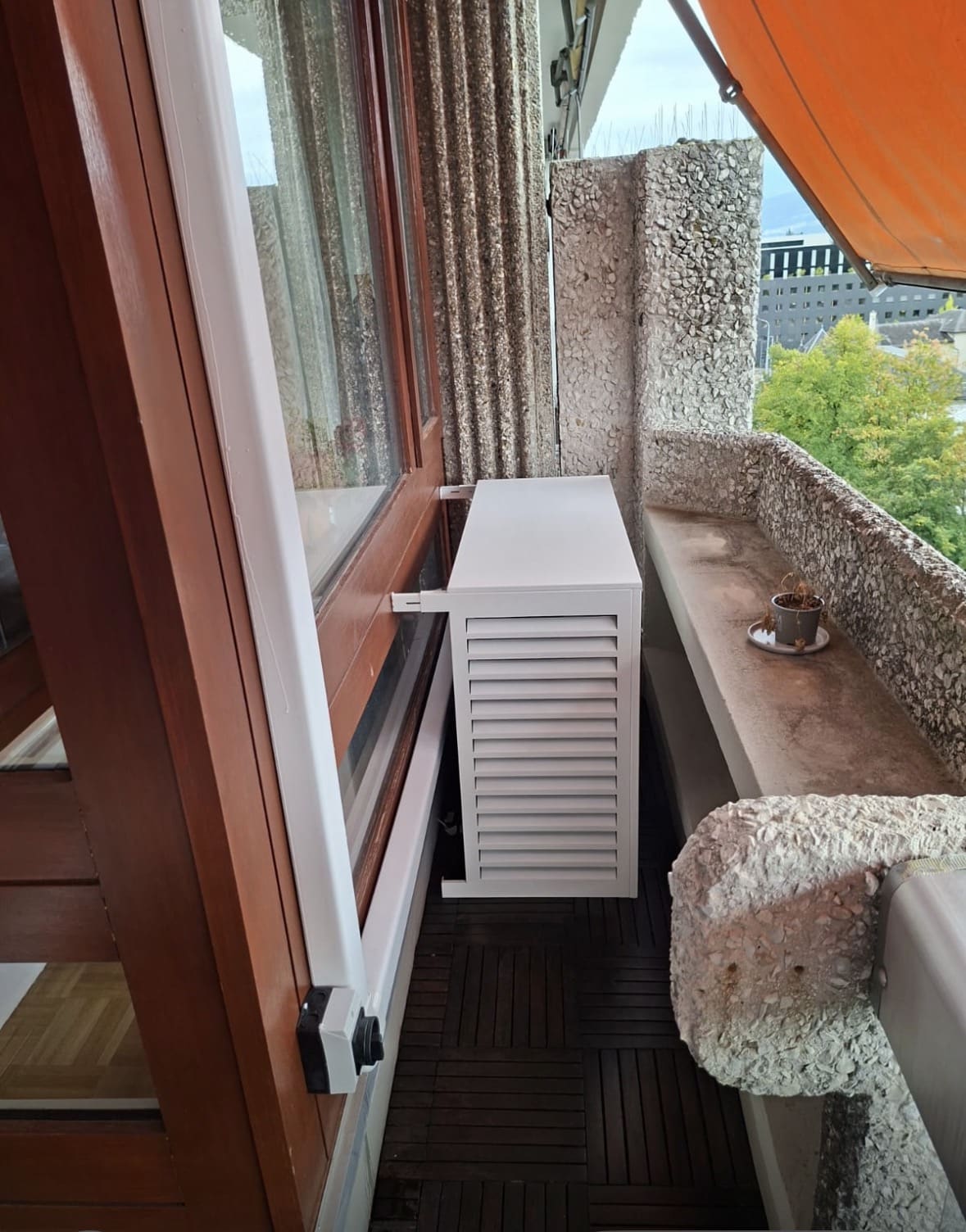 Vue du balcon de l'attique avec un second cache-groupe blanc installé contre la façade