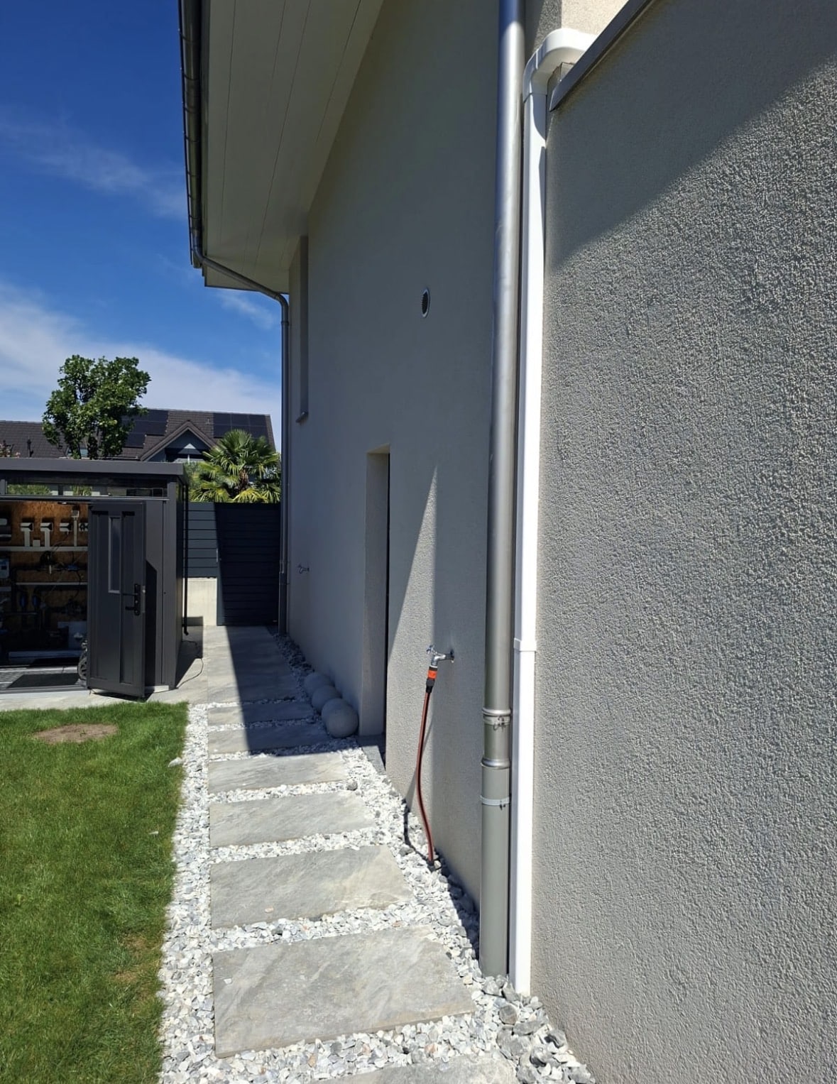 Passage latéral de la villa avec cheminement en dalles et gravier une fois le chantier terminé