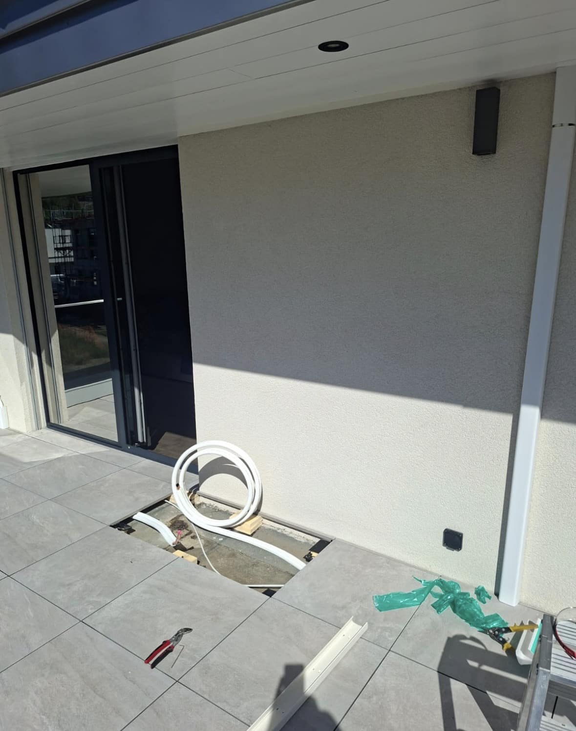 Dalles de terrasse ouvertes et conduite frigorifique passée sous le carrelage