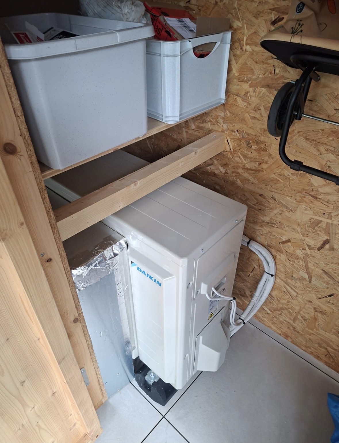 Groupe extérieur Daikin installé dans une armoire, raccordé à une gaine isolée et posé sur plots