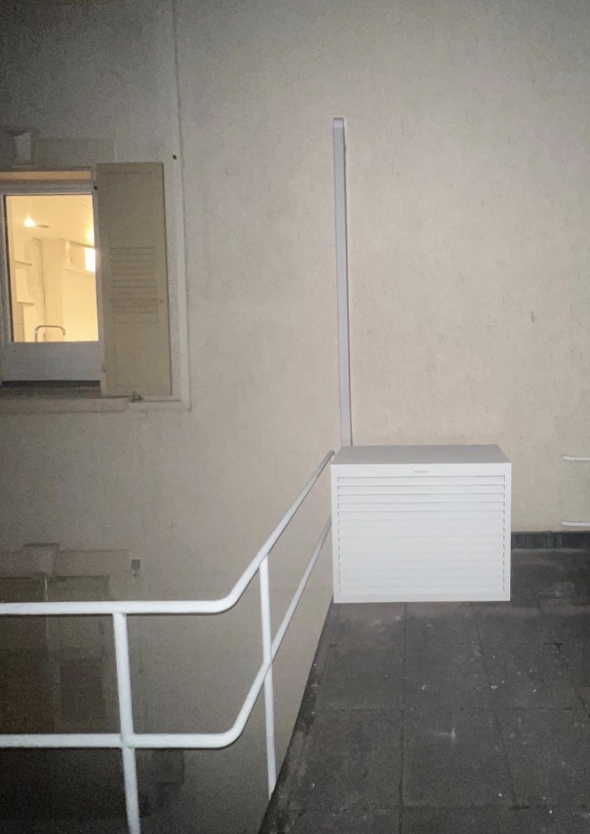 Groupe extérieur Daikin habillé d'un cache Decoclim blanc fixé contre la façade d'un immeuble