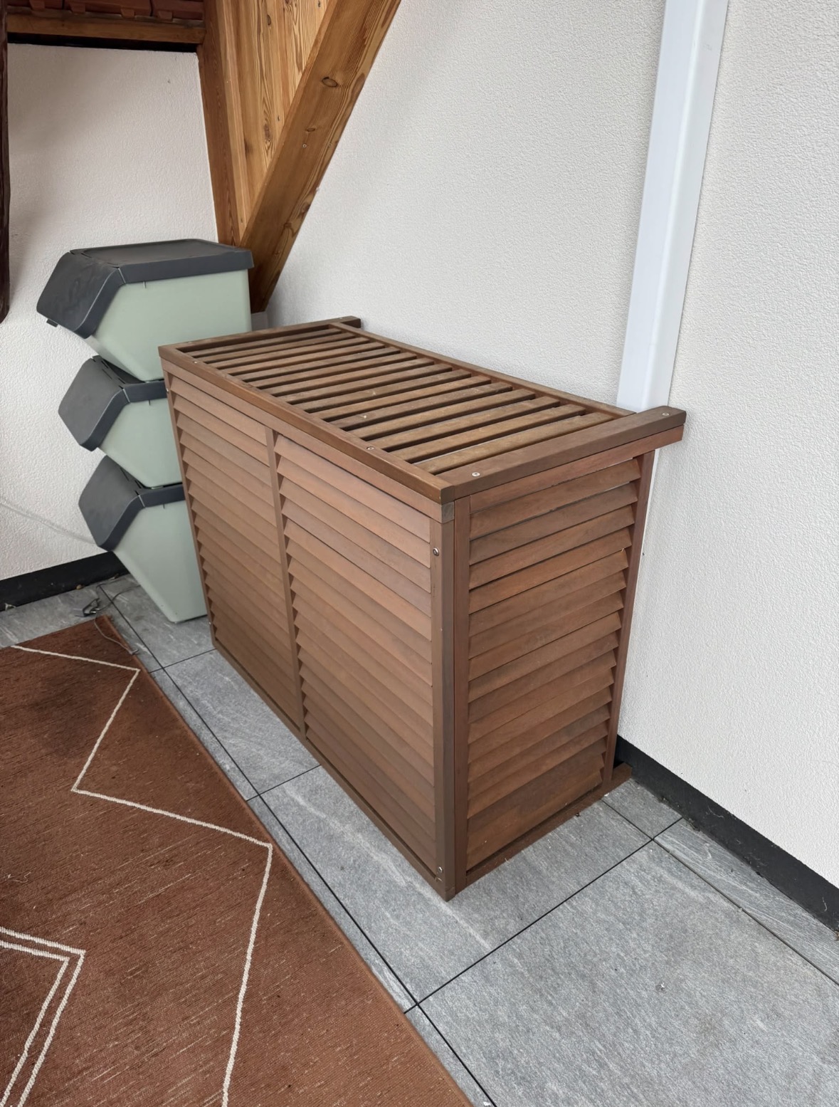 Cache Decoclim en bois à lames ajourées recouvrant l'unité extérieure de climatisation