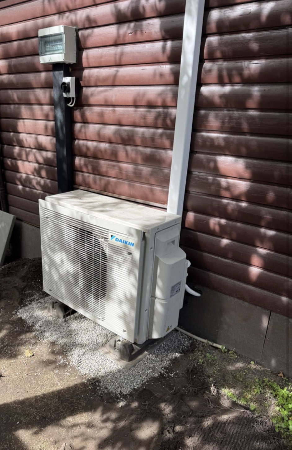 Vue rapprochée de la pompe à chaleur Daikin avec son coffret électrique et ses liaisons protégées en goulotte blanche
