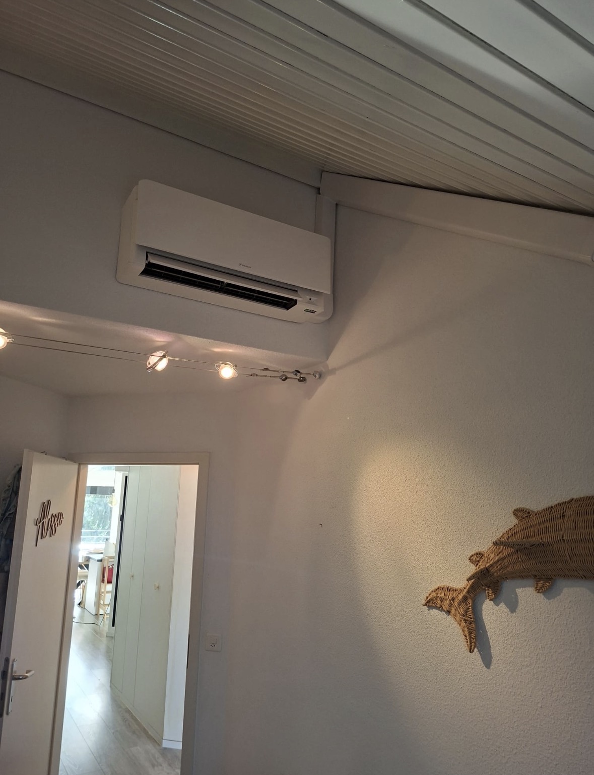 Unité murale Daikin blanche posée en hauteur dans une chambre sous toiture