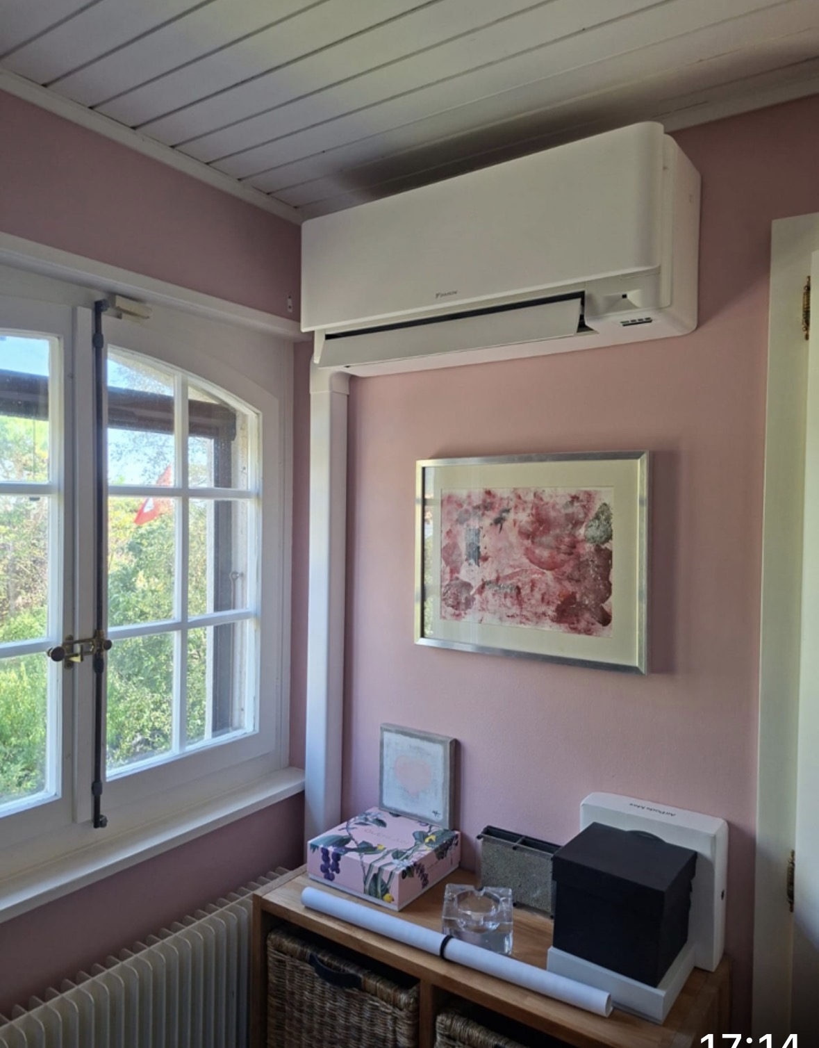 Split mural Daikin posé au-dessus d'une console dans une pièce aux murs rose poudré