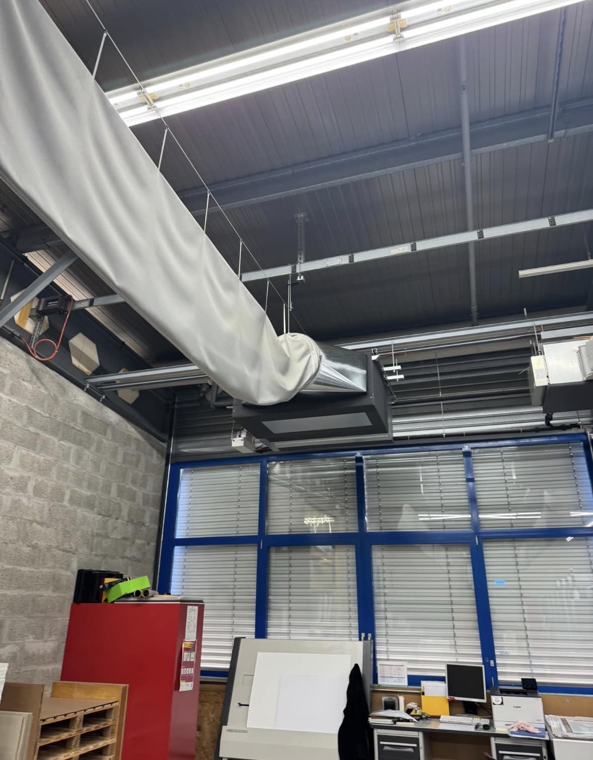 Gaine textile de diffusion d'air traversant l'atelier d'imprimerie au-dessus des postes de travail