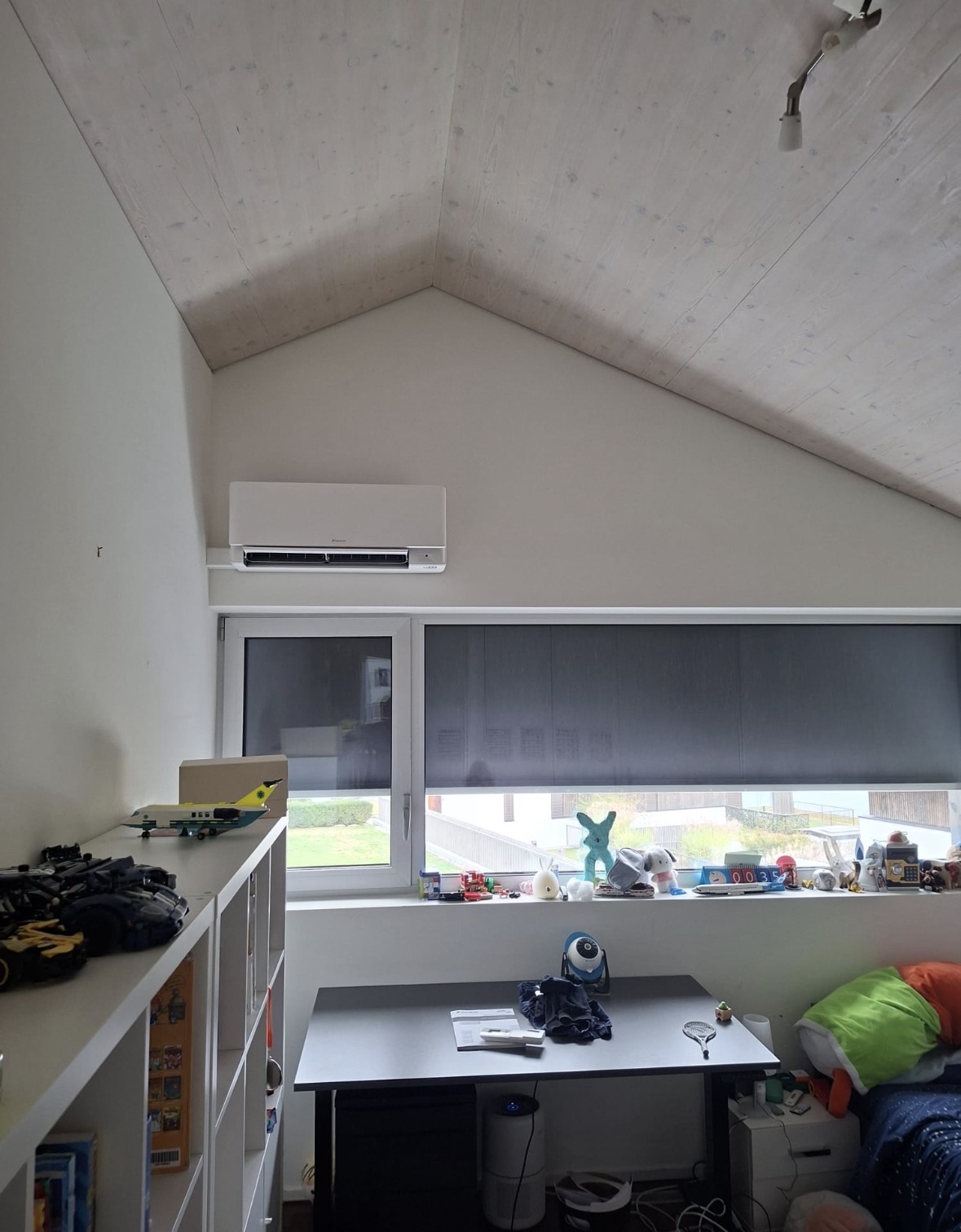 Unité intérieure Daikin fixée au-dessus d'une fenêtre dans une chambre d'enfant sous comble
