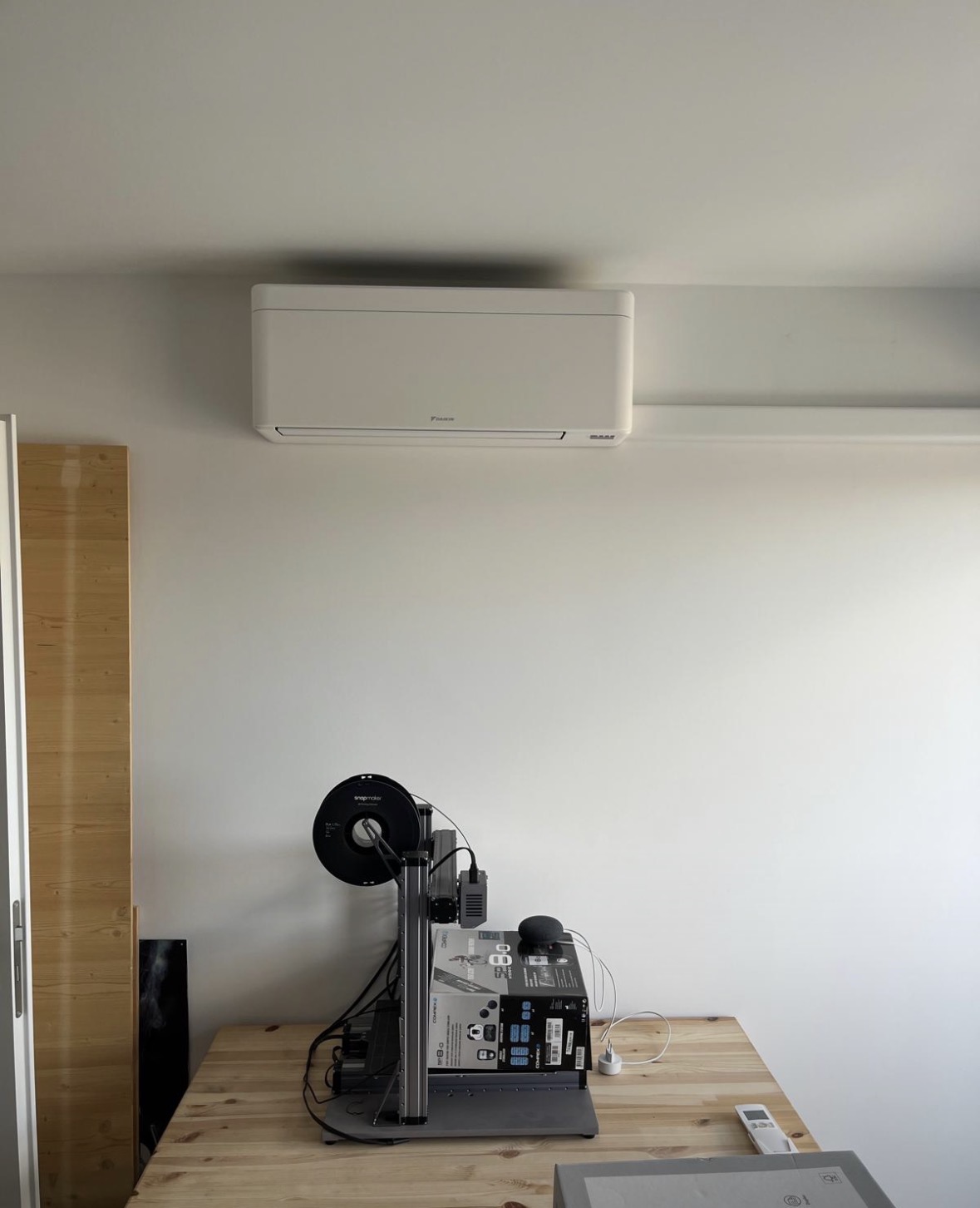 Unité intérieure Daikin fixée au-dessus d'un bureau en bois clair