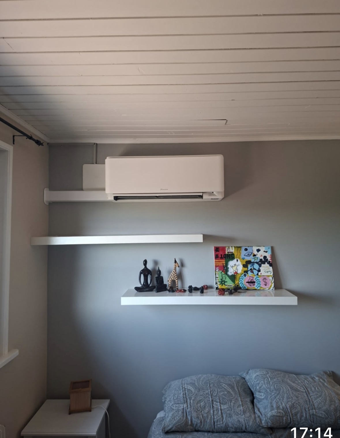 Unité intérieure Daikin fixée au-dessus d'étagères blanches dans une chambre grise