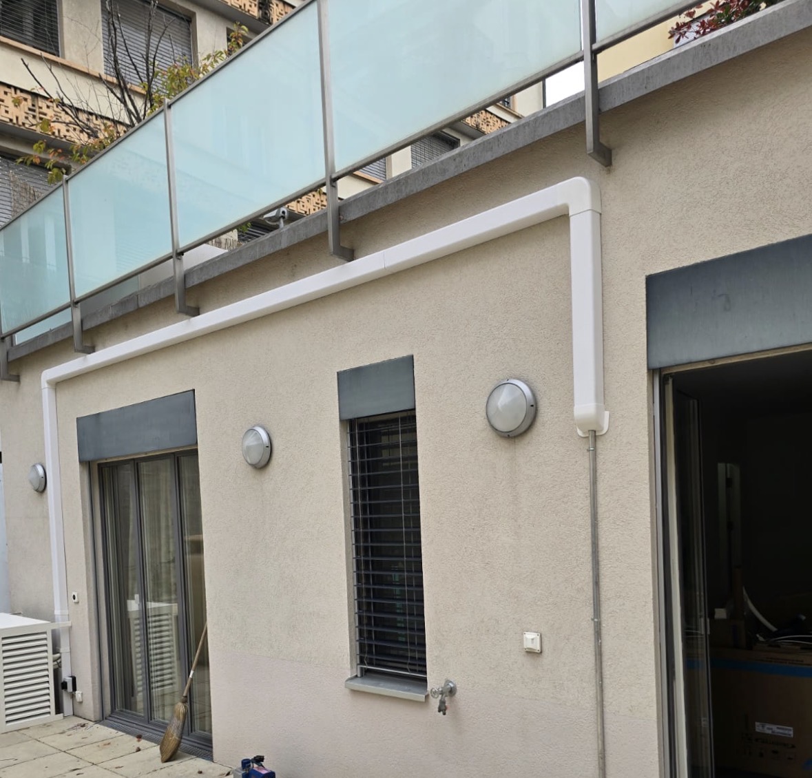Goulotte blanche suivant l'angle de la façade pour dissimuler les liaisons frigorifiques