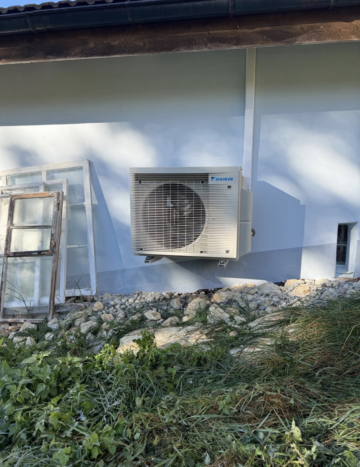 Unité extérieure Daikin fixée sur consoles en façade sous l'avant-toit