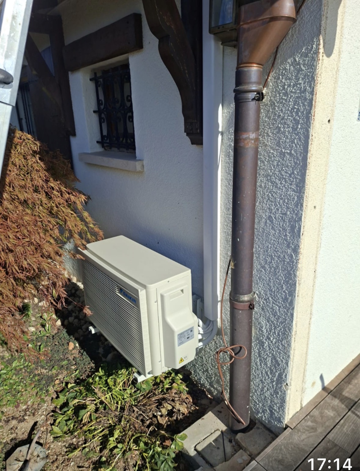 Unité extérieure Daikin posée sur supports au sol le long de la façade crépie de la villa