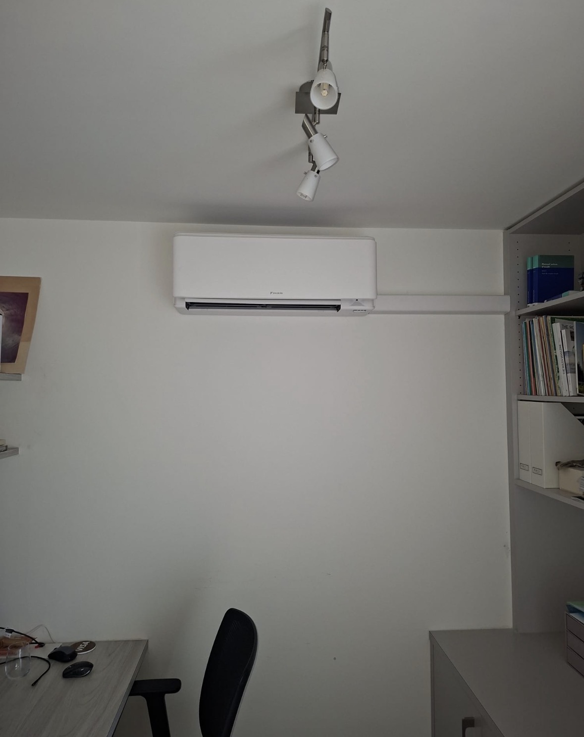 Unité murale Daikin dans un bureau, avec finition blanche alignée sur la bibliothèque